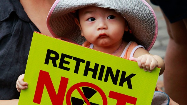 CriançaCriança durante protesto em frente à embaixada do Japão em Bancoc, capital da Tailândia, contra a decisão do governo japonês de reativar dois reatores nucleares em Fukushima