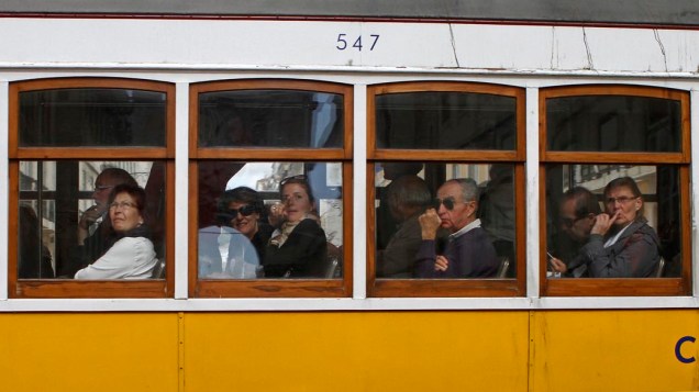Passageiros em bonde elétrico na cidade de Lisboa, em Portugal