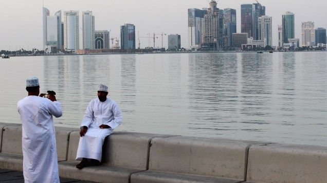 Homens posam para fotografia na área de West Bay, em Doha