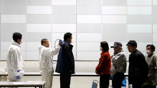 Oficiais medem nível de radiação em pessoas a 60km da usina nuclear de Fukushima, Japão