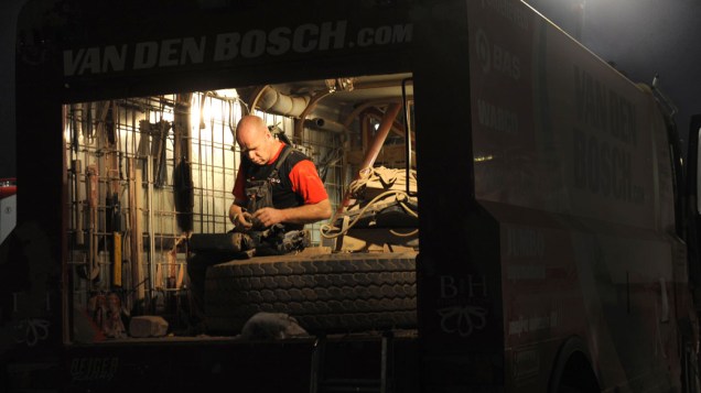 Mecânico trabalha em caminhão após terminar a quinta etapa do rali Dakar 2011