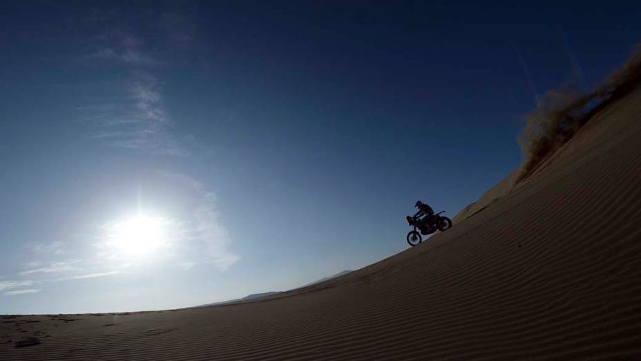 Motociclista atravessa o deserto de Nazca, no Peru, durante o rali Dacar 2013