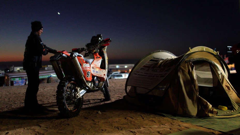 Motociclista da Namíbia chega ao acampamento após a quinta etapa do rali Dakar 2011