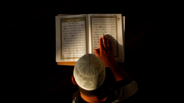 Muçulmano lê o Alcorão em uma mesquita da Palestina durante a oração matinal do Ramadã