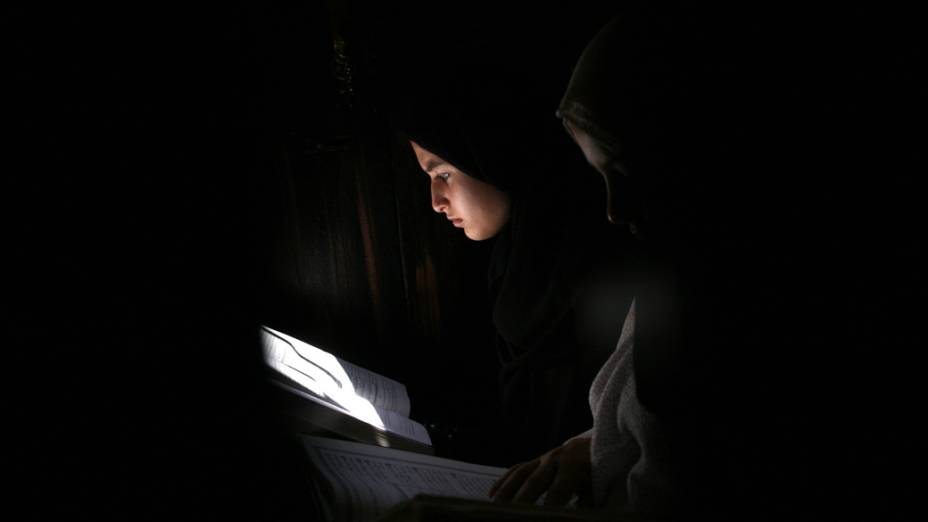 Mulher palestina lê o Corão na Cisjordânia, durante a primeira sexta-feira do Ramadã