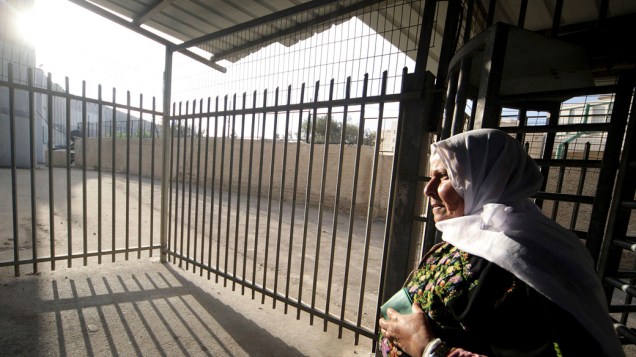 Mulher palestina cruza o ponto de controle de entrada para Jerusalém, onde irá participar das orações da primeira sexta-feira do Ramadã