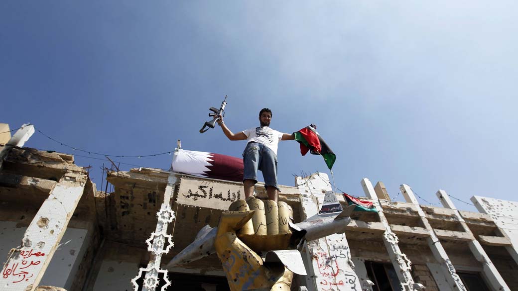 Rebelde líbio comemora a ocupação do quartel-general de Kadafi em Trípoli, Líbia: objetos recolhidos no local estarão no museu de Misrata