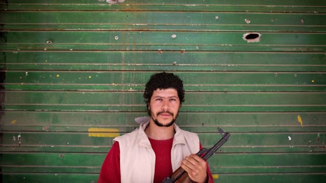 Em Benghazi, comerciante líbio, que agora participa das forças rebeldes, em frente à sua loja baleada
