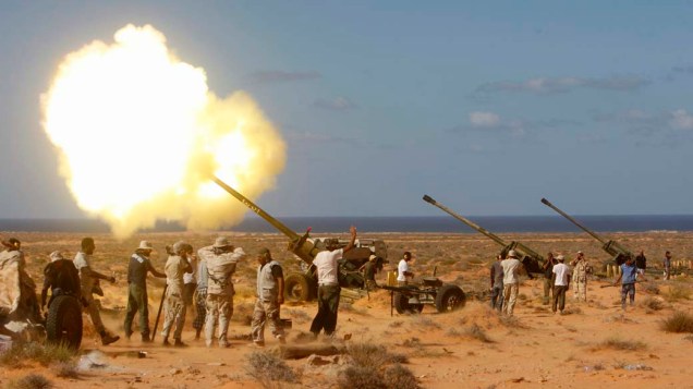 Rebeldes líbios lançam fogo em Om El Khanfousa, a leste de Sirte, Líbia