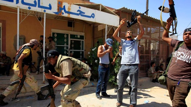 Rebeldes líbios escondem-se durante ataque na cidade de Bani Walid, Líbia