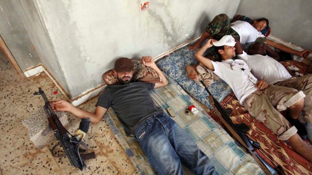 Rebeldes descansam em prédio abandonado na cidade de Bani Walid, reduto pró-Kadafi