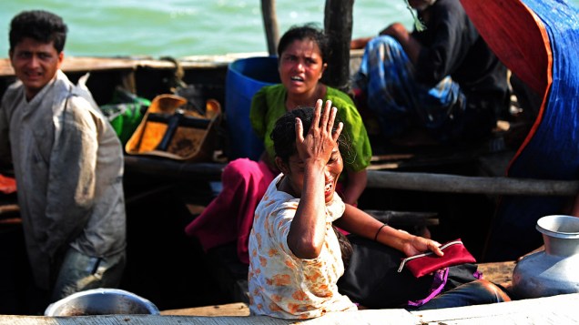 Mulher muçulmana Rohingya, chora em um barco interceptado quando tentavam atravessar o rio Naf em Bangladesh