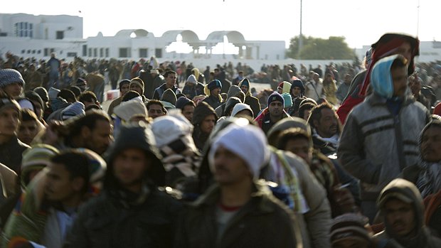 Refugiados líbios aguardam ônibus em Ben Gardane, na Tunísia, após fugirem do seu país
