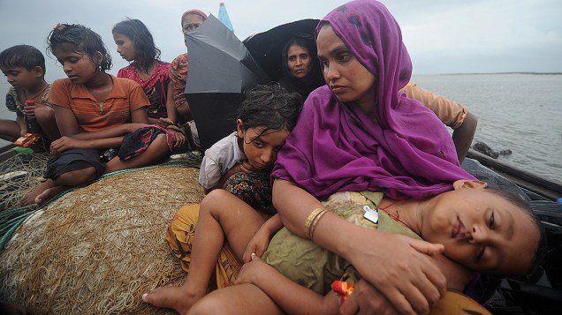 Mulheres e crianças muçulmanas Rohingya em um barco interceptado quando tentavam atravessar o rio Naf em Bangladesh