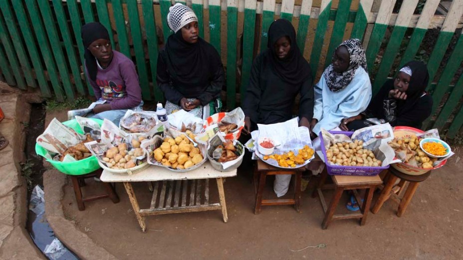 Garotas vendem comida do lado de fora de uma mesquita na favela de Kibera no Quênia. Os núbios viveram no Quênia há mais de um século, mas regularmente lhes são negados cartões de identidade nacionais e passaportes que eles precisam para trabalhar, votar, viajar, abrir uma conta bancária, frequentar a universidade ou entrar em edifícios do governo