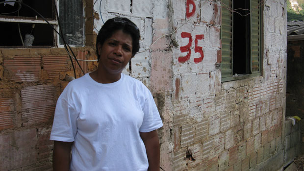 Regiane Correia Peres, na frente da casa que ficou destruída depois da tragédia