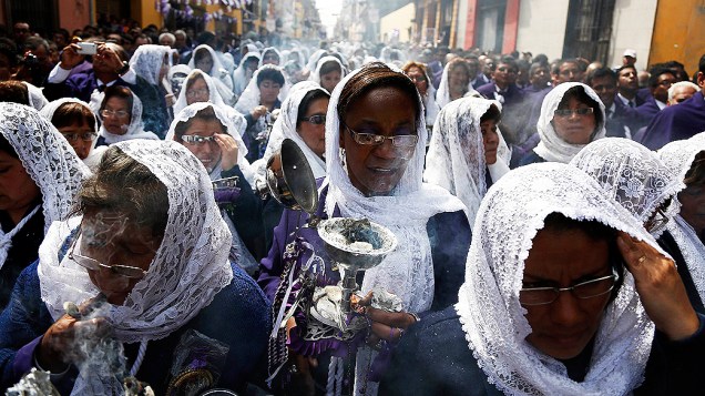 Mulheres levam incenso durante a procissão do Senhor dos Milagres, ícone religioso católico no Peru, no centro de Lima