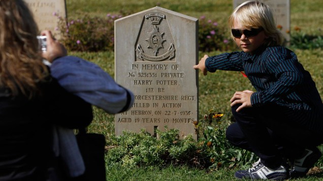 Menino posa ao lado de túmulo de soldado britânico chamado Harry Potter, durante as celebrações do "Remembrance Day", em Israel