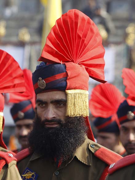 Policial vestindo uniforme cerimonial assiste ao desfile do Dia da República da Índia em Srinagar