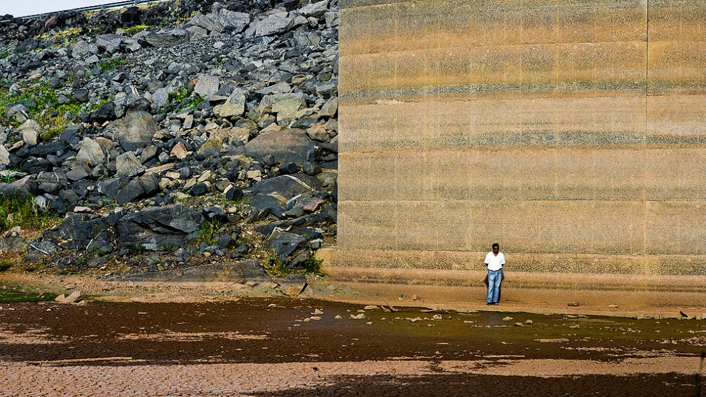 Funcionário caminha pela área da represa Jaguari, que faz parte do Sistema Cantareira, em Bragança Paulista, no interior de São Paulo