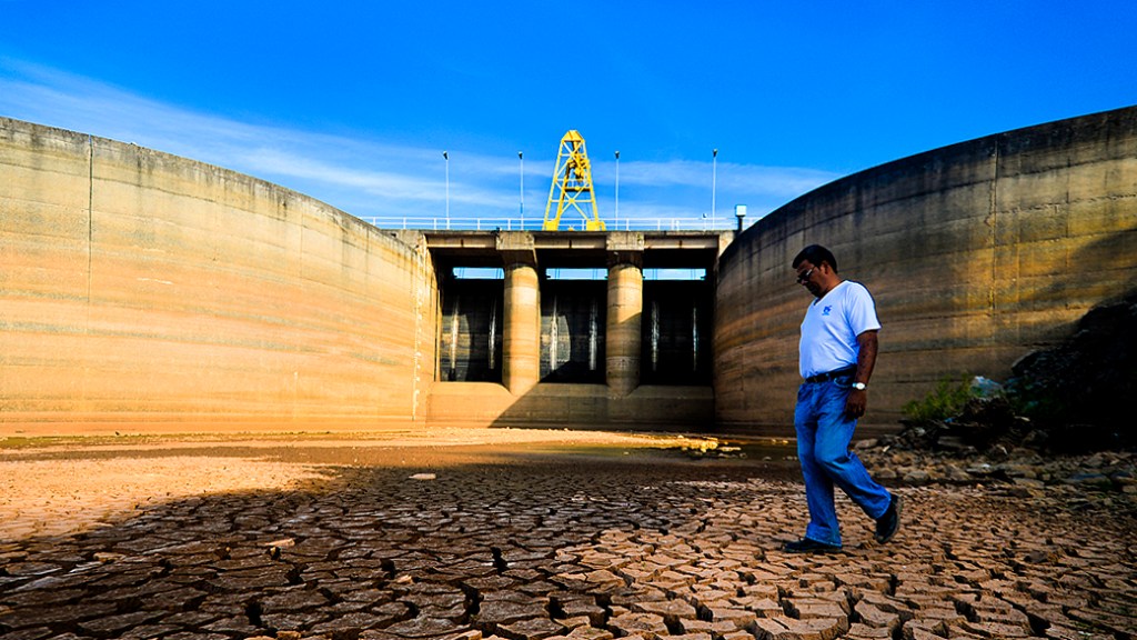 Funcionário caminha pela área da represa Jaguari, que faz parte do Sistema Cantareira, em Bragança Paulista, no interior de São Paulo