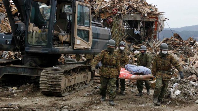 Resgate de vítimas em vilarejo destruído pelo terremoto e tsunami em Rikuzentakata, Japão