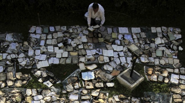 Restaurador seca livros danificados em incêndio, causado durante confrontos, no Instituto do Egito, fundado em 1798, que contém mais de 20.000 documentos e manuscritos, no Cairo