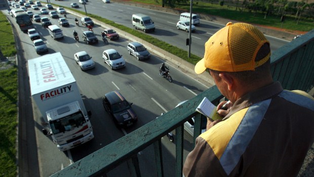 Agente da Companhia de Engenharia de Tráfego (CET) fiscaliza lei de restrição a caminhões na Marginal Tietê, em São Paulo