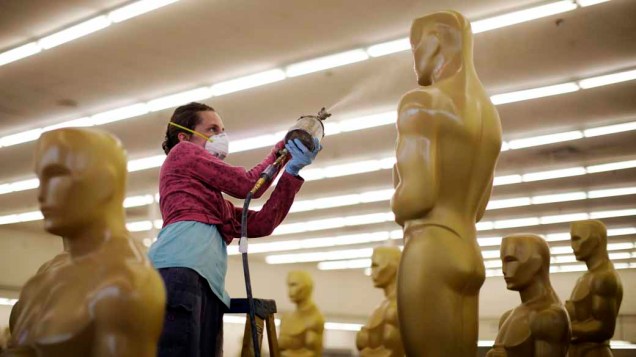 Mulher retoca a pintura de estátua do Oscar durante os preparativos para a 83ª edição, em 2011, da maior premiação do cinema