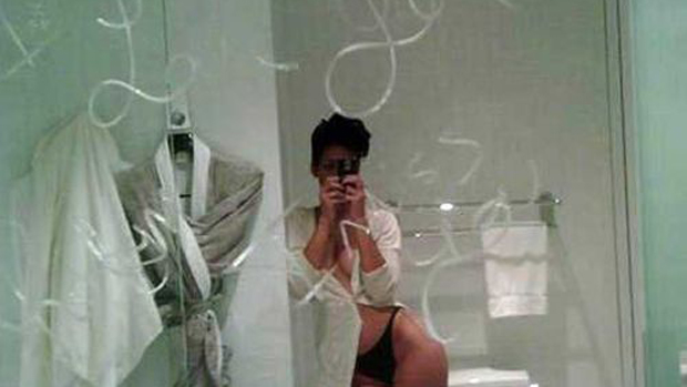 A cantora Rihanna tira foto de seu reflexo no espelho