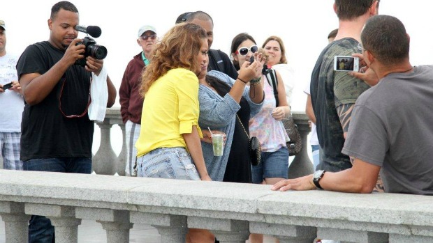 Rihanna posa com fãs no Corcovado, com copo de caipirinha na mão