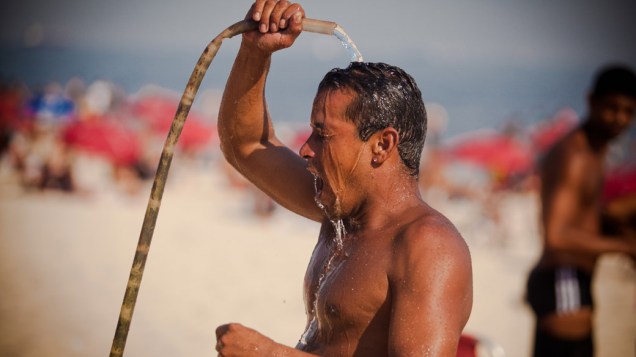 Banhista se refresca em ducha. Os termômetros chegaram a registrar 40 graus de temperatura, no Rio de Janeiro