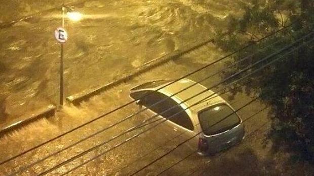Rio: carro fica quase submerso em rua alagada