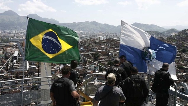 Policiais colocam as bandeiras do Brasil e do Estado do Rio de Janeiro após a ocupação do Complexo do Alemão em 28 de novembro