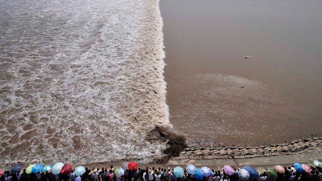 Turistas se reúnem na margem do rio Qiantang para assistir a maré subindo, na cidade chinesa de Haining