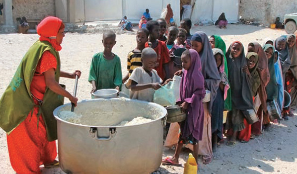 Agonia africana - crianças somalis aguardam, em fila, por um prato de comida: a degradação do ambiente está diretamente relacionado à pobreza endêmica
