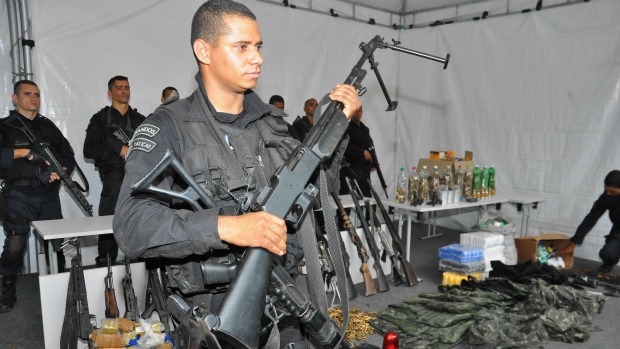 Policial apresenta armas apreendidas na Rocinha e no Vidigal: uma das metralhadoras tem capacidade para derrubar um helicóptero