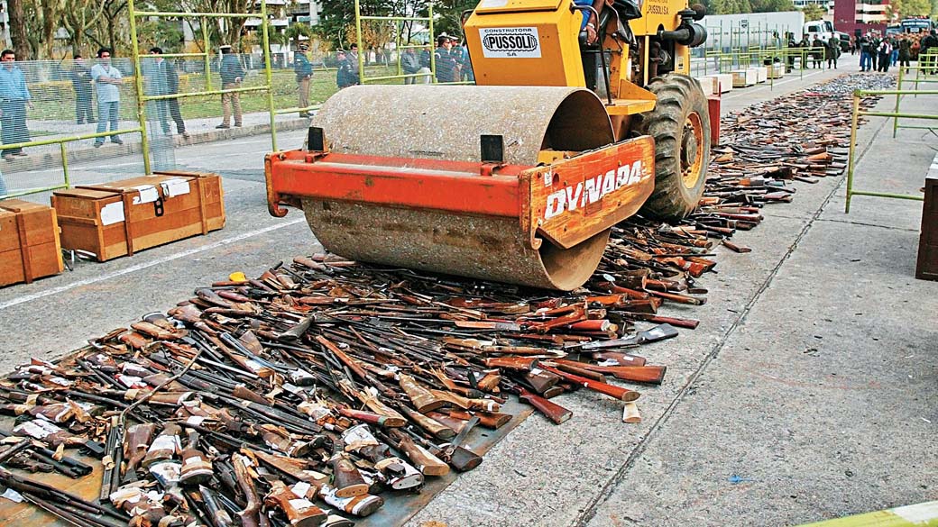 Rolo compressor destruindo armas apreendidas durante campanha de desarmamento