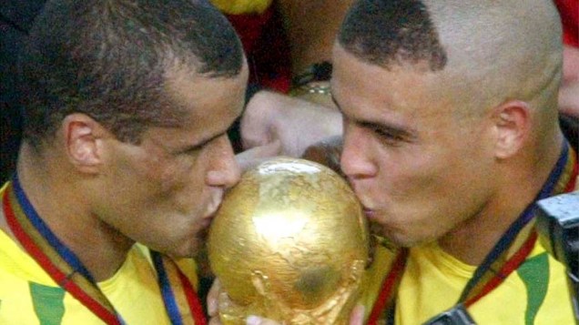 Destaques da seleção brasileira na Copa de 2002, na Coreia do Sul e no Japão, Rivaldo e Ronaldo beijam a taça