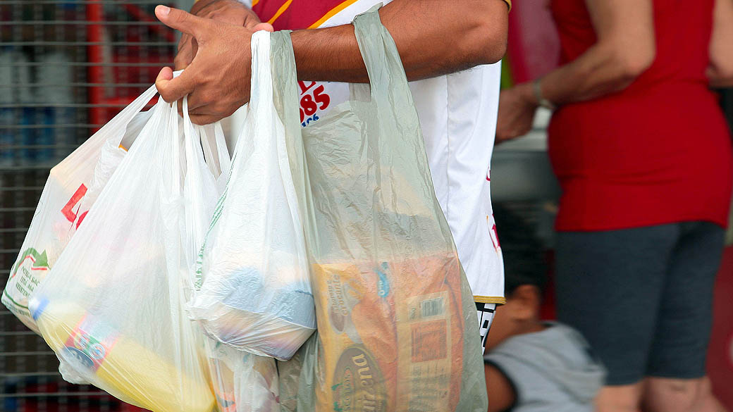 Consumidor carrega compras em sacola plástica
