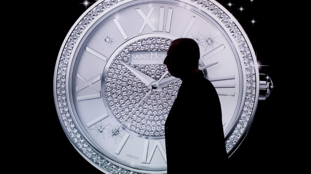 Homem passa em frente a anúncio da fabricante de relógios francesa Saint Honore em Basel, Suíça