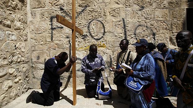 Turistas cristãos rezam diante da Igreja do Santo Sepulcro, em Jerusalém