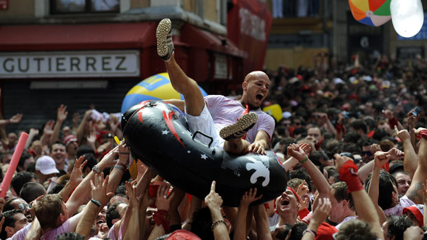 Homem é carregado por foliões durante abertura do festival de São Firmino