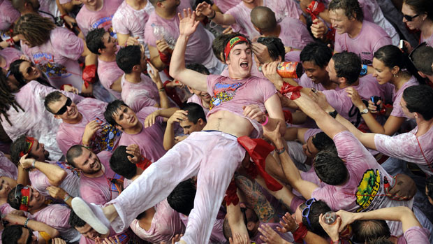 Homem é carregado por foliões durante abertura do festival de São Firmino