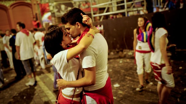 Casal se beija em meio a tradicional corrida de touros durante o festivla de São Firmino, em Pamplona, Espanha