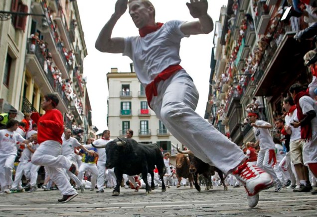 Homens correm de touro durante o festival São Firmino, na Espanha