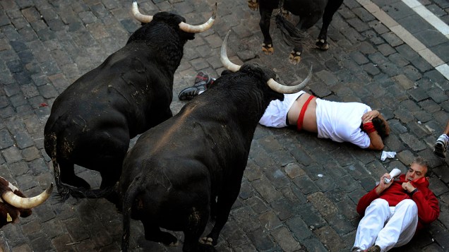 Foliões se atropelam e caem durante corrida com touros do tradicional festival de São Firmino, em Pamplona, na Espanha