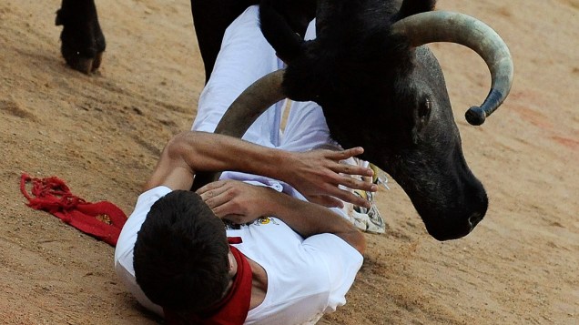 Touro atinge um participante do sétimo dia de corridas de touros no tradicional festival de San Fermino na cidade espanhola de Pamplona