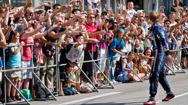 Sebastian Vettel joga cartões autografados para fãs em Heppenheim, na Alemanha, em 18/07/2010