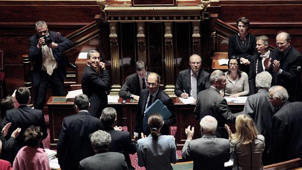 O ministro do Trabalho da França, Eric Woerth, é felicitado por membros do governo depois de o Senado aprovar a reforma da previdência